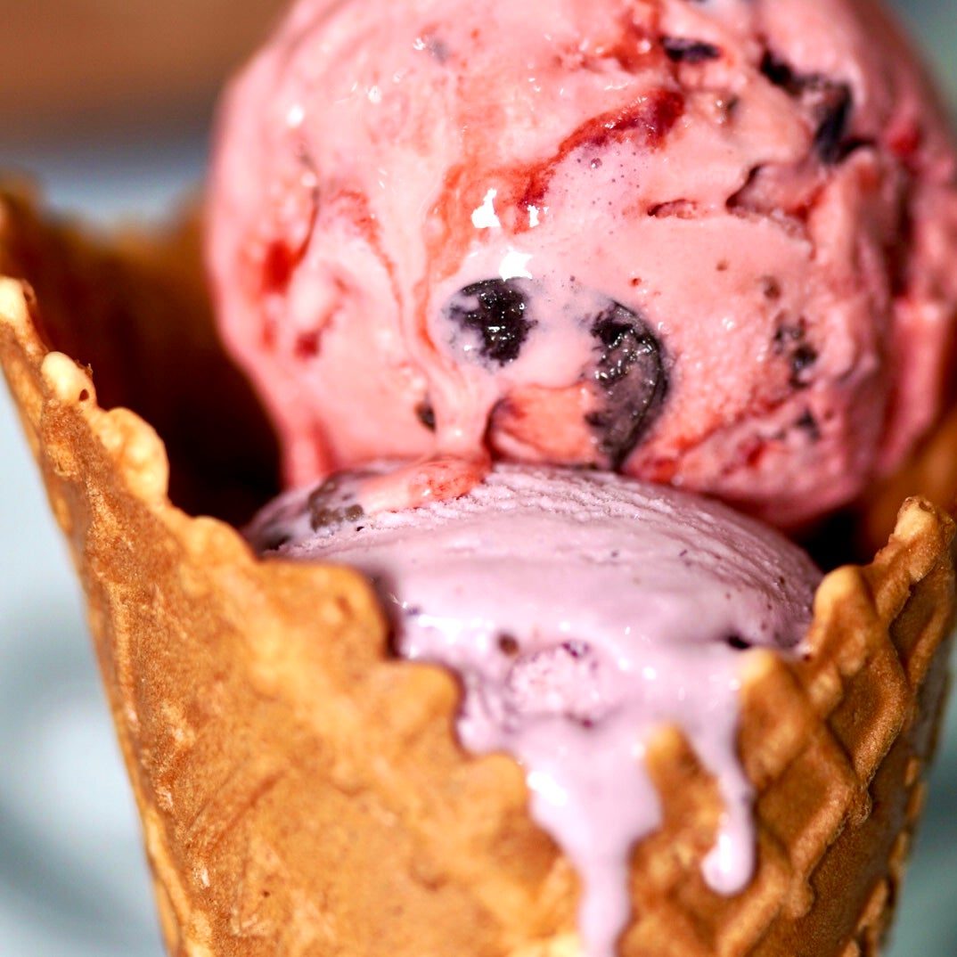 Double Scoop Of Fresh Strawberry Ice Cream In Waffle Cone Against